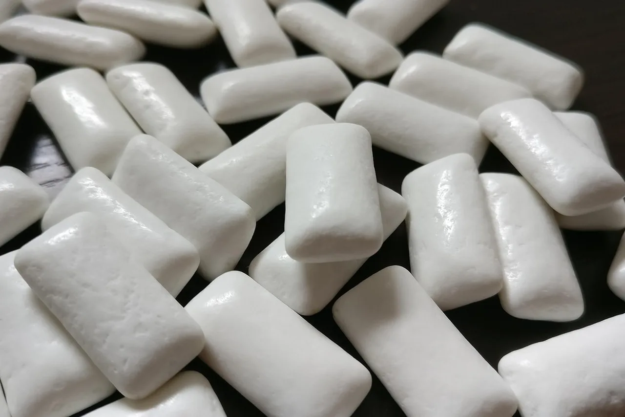 Pieces of white chewing gum, a common source of xylitol.