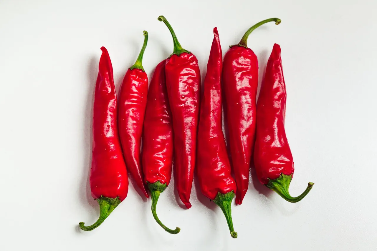 Several red chili peppers on a white background.