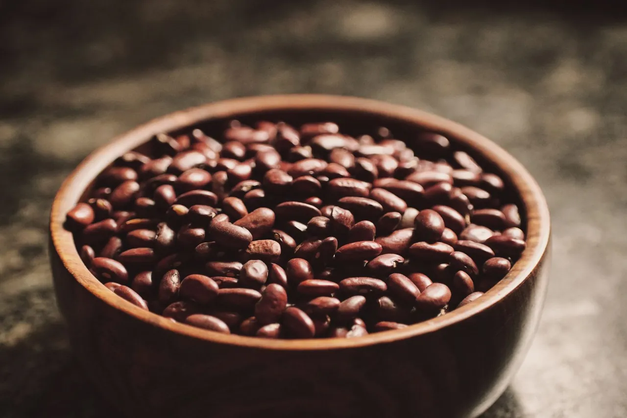 A wooden bowl filled with beans.