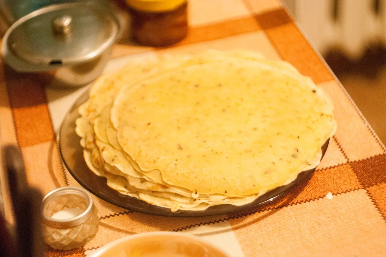 A stack of homemade corn tortillas on a table.